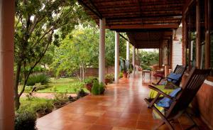 una veranda con due sedie a dondolo su una casa di Gitanjali Homestay a Mysore