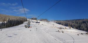 un grupo de personas montando un remonte en una pista cubierta de nieve en Zespół Tatry - Hotel Tatry i Budynek Turystyczny, en Murzasichle