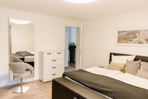 Un dormitorio con una cama, una silla y un espejo. en Brehm Living, en Kandel