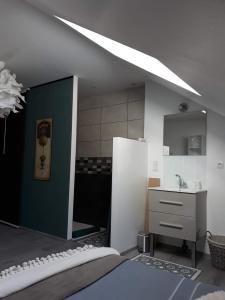 una camera con letto, lavandino e specchio di La CASITA a Bléré