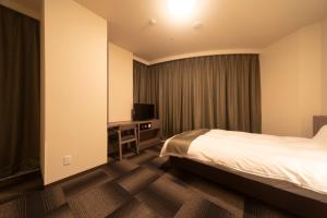 Ein Bett oder Betten in einem Zimmer der Unterkunft Dormy Inn Korakuen