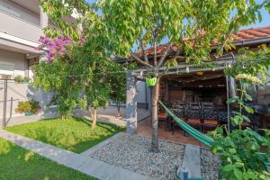 a garden with a hammock in front of a house at Apartments Luky in Zadar