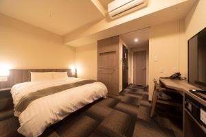 Ein Bett oder Betten in einem Zimmer der Unterkunft Dormy Inn Korakuen