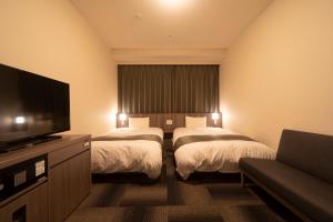Ein Bett oder Betten in einem Zimmer der Unterkunft Dormy Inn Korakuen