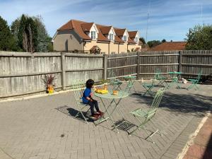 a little boy sitting at a table in a backyard at Stanwell Stansted Airport in Takeley