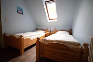 2 Einzelbetten in einem Zimmer mit Fenster in der Unterkunft Ferienbauernhof Mau in Fehmarn