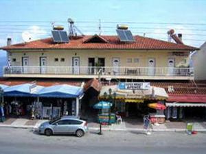 un edificio con un coche aparcado delante de él en Drenos Rooms view, en Kallithea Halkidikis