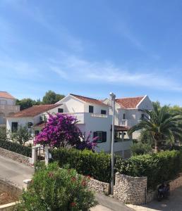 a white house with purple flowers and bushes at Holiday Home Brac in Supetar