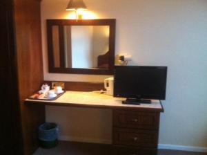 
a bathroom with a mirror and a sink at Mourne Country Hotel in Newry
