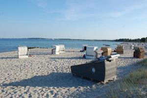 a beach with many chairs and the water at Schlafstrandkorb Nr. 1 in Sierksdorf