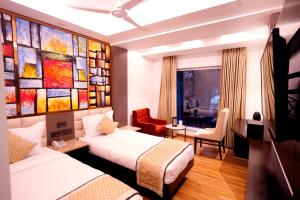 a hotel room with two beds and a painting on the wall at Hotel City Pride in New Delhi