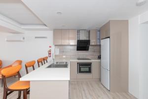 a kitchen with white appliances and orange chairs at Christmas Island Apartments in Flying Fish Cove