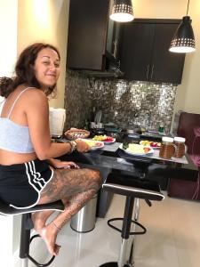 a woman sitting on a chair in a kitchen at The Villa's Kubu Sandan in Kintamani