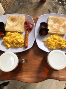two plates of breakfast food on a wooden table at The Villa's Kubu Sandan in Kintamani