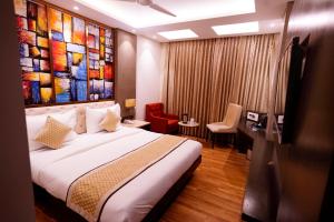 a hotel room with a bed and a painting on the wall at Hotel City Pride in New Delhi
