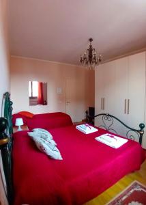 a bedroom with a large red bed with red sheets at Bed And Breakfast Loriana in Arezzo
