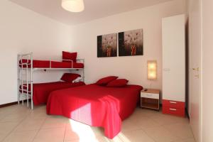 1 dormitorio con 2 literas con sábanas rojas en B&B Residenza Bianco, en Castellana Grotte