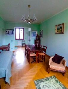 ein Wohnzimmer mit einem Esstisch und grünen Wänden in der Unterkunft Bed And Breakfast Loriana in Arezzo