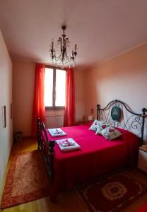 1 dormitorio con 1 cama grande de color rojo y lámpara de araña en Bed And Breakfast Loriana, en Arezzo
