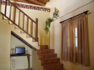 a living room with a staircase and a television at Finca El Manzano in Cortegana