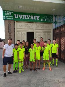 a group of people posing for a picture in front of a hotel at Uvaysiy family guest house in Margilan