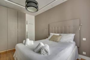 a bedroom with a large white bed with towels on it at Design Apt 4 pers - Paris 8ème in Paris