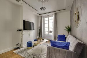 a living room with a couch and blue chairs at Design Apt 4 pers - Paris 8ème in Paris