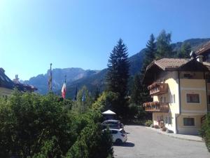 a building with a car parked in a driveway at Appartamenti Riz Claudio in Campitello di Fassa