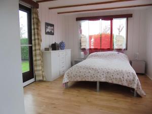 1 dormitorio con 1 cama, vestidor y ventanas en Ferienpark Vislust Haus Angel Niederlande Ijsselmeer, en Wervershoof