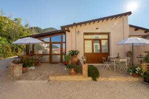 a house with two umbrellas and a patio at Agriturismo Monte Cologna in Foligno