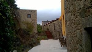 帕雷迪什迪科拉的住宿－Casa da Pedreira，石头建筑中带椅子和楼梯的小巷