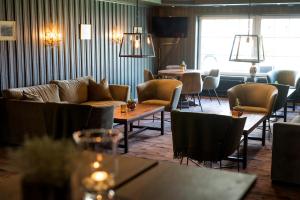a living room with couches and tables and chairs at Geilo Hotel in Geilo