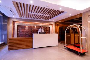 a man standing at a counter in a lobby at Hotel City Pride in New Delhi