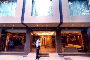 Hotel Ritz - New Delhi, Paharganj في نيودلهي: رجل واقف امام مبنى