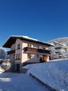 a house in the winter with snow on the ground at Landhaus Theresia in Sankt Martin am Tennengebirge