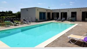 una gran piscina con sillas y un edificio en HISTOIRE D'Ô - Les Piscines - Chambres d'hôtes, en Bezouce