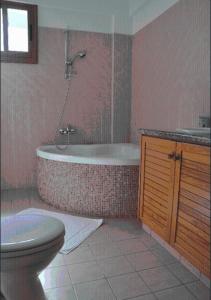 a bathroom with a tub and a toilet and a sink at Amalia Villa in Polis Chrysochous