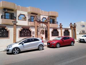 twee auto's geparkeerd voor een gebouw bij TheCastle Hotel in Dahab