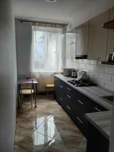 a kitchen with a table and a stove top oven at Apartment in Serbska Lviv in Lviv