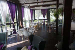 a restaurant with tables and chairs and large windows at Domki&Apartamenty Koszarka in Gródek Nad Dunajcem