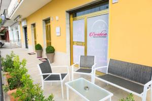 two chairs and a table in front of a building at Desidora B&B in Mirabella Eclano