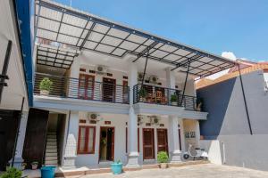 a large house with a balcony and a building at Capital O 1566 El Reyshi Family Residence in Banyuwangi