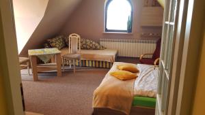 a small room with two beds and a table at Noclegi Barbara in Czorsztyn