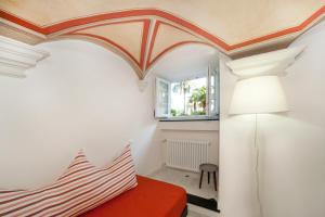Un dormitorio con una cama roja y un techo blanco. en Old Villa stylish apartment, en Génova