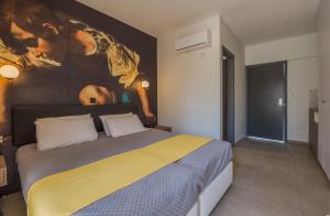 een slaapkamer met een bed met een schilderij aan de muur bij Narcissos Waterpark Resort in Protaras