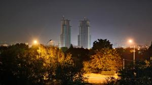 un perfil urbano por la noche con dos edificios altos en Domus Aparthotel, en Skopje