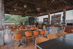 un restaurante con mesas y sillas en una habitación en RedDoorz Premium @ Jalan Pal 10 Jambi, en Jambi