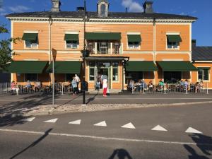 奥萨Orsa Station Bed and Breakfast的一群人站在建筑物外面