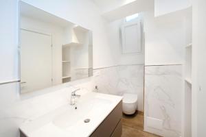 Baño blanco con lavabo y aseo en Old Villa stylish apartment, en Génova