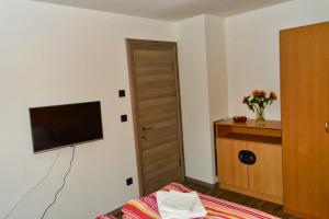 1 dormitorio con 1 cama y TV en la pared en Homestay Manolov en Múnich